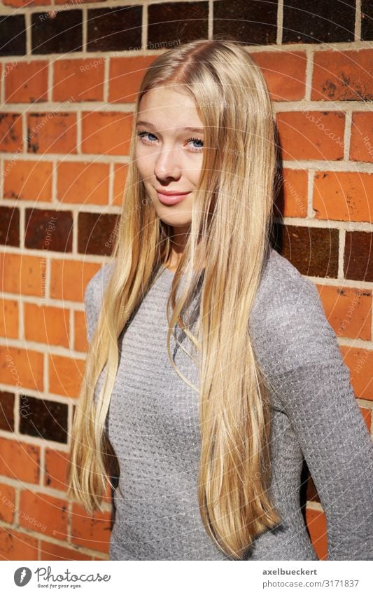 weiblicher Teenager lehnt an Mauer Lifestyle Mensch feminin Junge Frau Jugendliche Erwachsene 1 13-18 Jahre 18-30 Jahre Wand Pullover blond langhaarig Lächeln