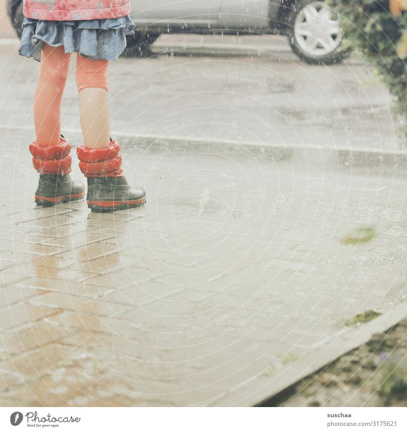 im regen .. Kind Mädchen Regen Regenwasser nass Wasser Beine Gummistiefel PKW Straße Asphalt Freude Sommer Hofeinfahrt Wetter