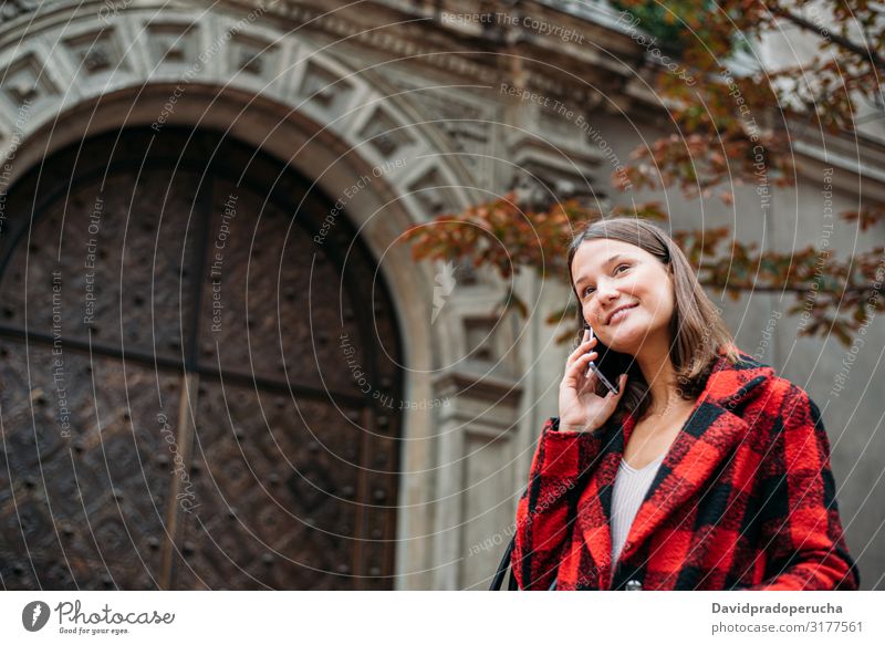 hübsche junge Frau zu Fuß auf der Straße mit Smartphone Zelle benutzend Technik & Technologie Lächeln Tageslicht Wegsehen Gerät Apparatur Gespräch im Freien