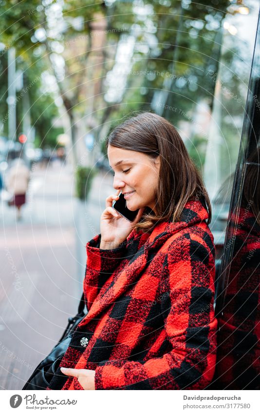 hübsche junge Frau steht auf Glas auf der Straße mit Smartphone Zelle benutzend Technik & Technologie Lächeln Tageslicht Wegsehen Gerät Apparatur Gespräch