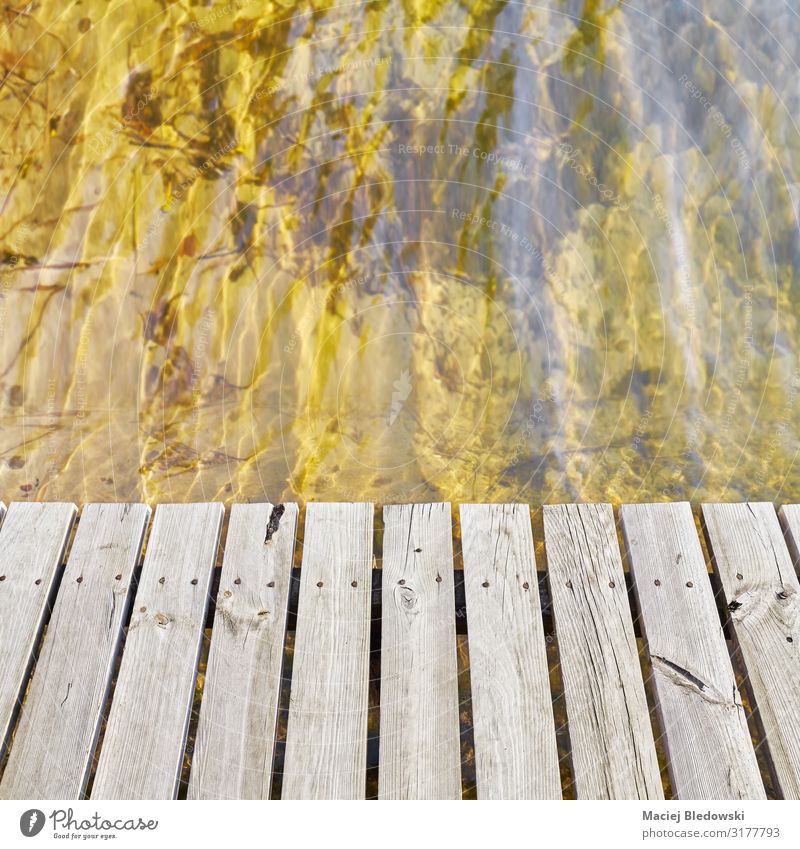 Hölzerne Brückenbretter an einem Wasser Wellen Natur Seeufer Flussufer natürlich Perspektive Holz Holzplatte Hintergrund Textfreiraum Windstille Schiffsplanken