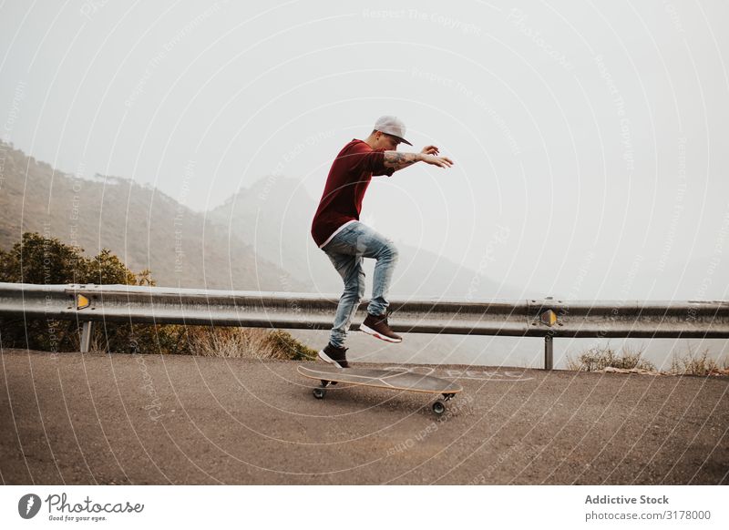 Trendige Skateboarderin mit Tricks in der Natur Mann Berge u. Gebirge Straße Ausritt Longboard springen Nebel Landschaft abgelegen Panorama (Bildformat)