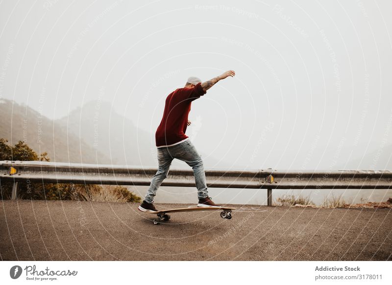 Trendige Skateboarderin mit Tricks in der Natur Mann Berge u. Gebirge Straße Ausritt Longboard springen Nebel Landschaft abgelegen Panorama (Bildformat)