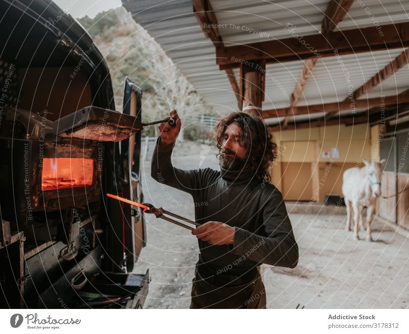 Hufschmied nimmt Hufeisen aus dem Ofen Schmelzofen heiß Pferdestall Ranch PKW Arbeit & Erwerbstätigkeit Handwerk Feuer Mann Erwachsene Metall geschmolzen Eisen