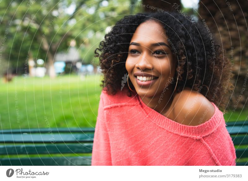Afro-amerikanische Frau, die im Park sitzt. Lifestyle Glück schön Erholung Garten Mensch feminin Erwachsene Natur brünett Lächeln Fröhlichkeit natürlich