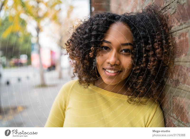 Porträt einer afro-amerikanischen Frau auf der Straße. schön Haare & Frisuren Erholung ruhig Fotokamera Mensch Erwachsene brünett Afro-Look Lächeln stehen