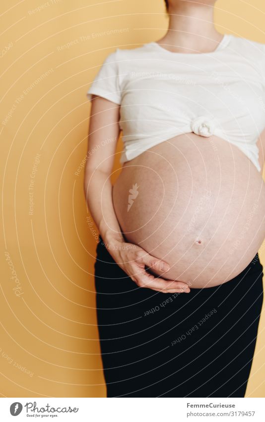 Schwangere Frau zeigt ihren Babybauch - neutraler Hintergrund feminin Junge Frau Jugendliche Erwachsene 1 Mensch 18-30 Jahre 30-45 Jahre Liebe schwanger