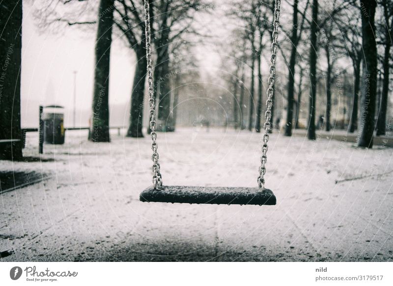 Menschenleerer Spielplatz im Winter Schaukel Theresienwiese München Außenaufnahme Schnee Einsamkeit ruhig kalt Kindheit Farbfoto Park trist schaukeln Analogfoto