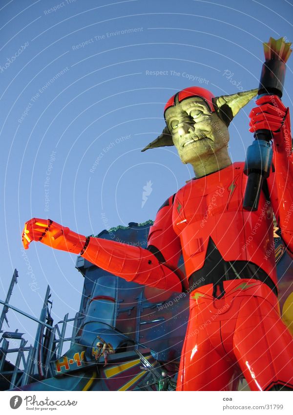 Spooky Freak Roboter rot Dämmerung Anzug Zukunft Froschperspektive obskur Ausstellung geisterbahn Fackel orange blau Ohr Jahrmarkt Himmel