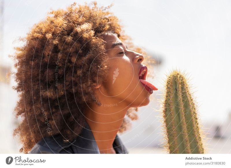Schwarze Frau, die vorgibt, Kaktus zu lecken. lutschen Leidenschaft geschlossene Augen Erotik Wunsch Afroamerikaner Entwurf Jugendliche verführerisch schwarz