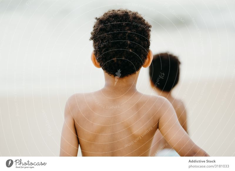 Schwarze Jungs spielen am Strand Brüder Meer Spielen Freude Zusammensein Sommer Wasser Junge ohne Hemd Barfuß Kind Geschwister Glück Wochenende Lifestyle