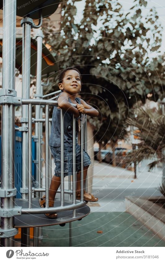 Lustiger schwarzer Junge auf dem Spielplatz lustig Park Gitter Kind klein niedlich Spielen Lifestyle Freizeit & Hobby ruhen Erholung Entertainment Aktion