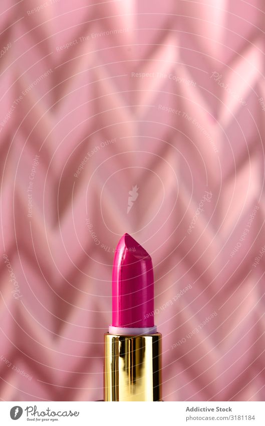 Lippenstift auf erhabenem rosa Chevron. Produkt- und Aufmachungskonzept Schminke Kosmetik Beautyfotografie Hintergrundbild Menschenleer Mode Stillleben Stock