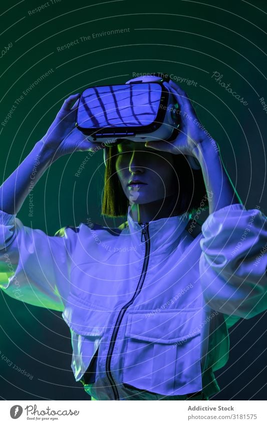 Frau im VR-Headset virtuell Realität Technik & Technologie neonfarbig Licht berühren Gerät digital Innovation Jugendliche Mensch Brillenträger asiatisch modern