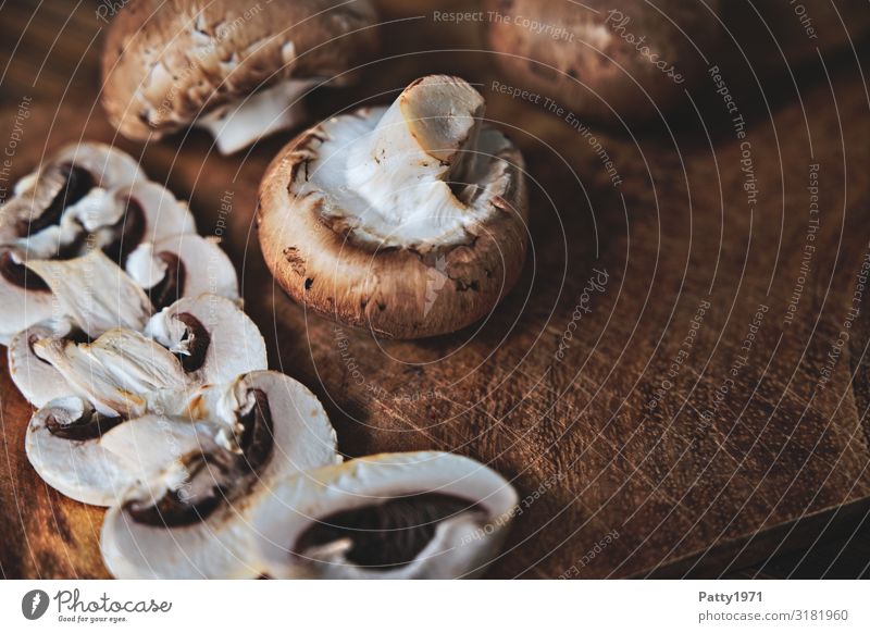 Champignons auf einem Holztisch Lebensmittel Pilz Ernährung Bioprodukte Vegetarische Ernährung Schneidebrett frisch lecker braun weiß genießen Foodfotografie