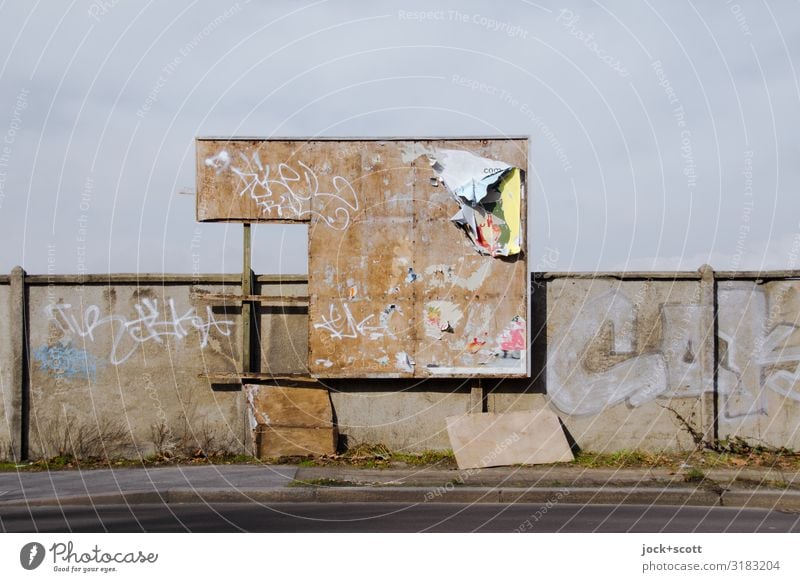 Kaputte Plakatwand an einer häßlichen Mauer Straßenkunst Pankow Bürgersteig dreckig hässlich kaputt trashig Endzeitstimmung Symmetrie Verfall Vergänglichkeit