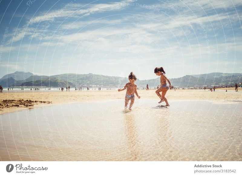 kleine Mädchen am Meer Strand Familie & Verwandtschaft Kind platschen Freude Sommer Glück Ferien & Urlaub & Reisen Wasser Mensch Lifestyle Spielen Natur Sonne