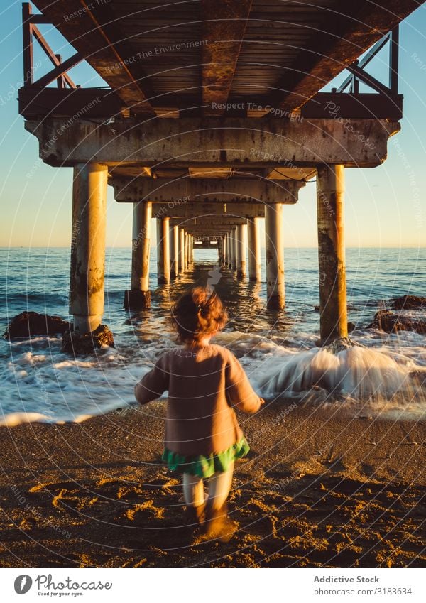 Rückansicht des Kindes unter einem Pier Mädchen laufen Anlegestelle Sonnenuntergang Natur Meer Strand Hintergrundbild Himmel Wasser Ferien & Urlaub & Reisen