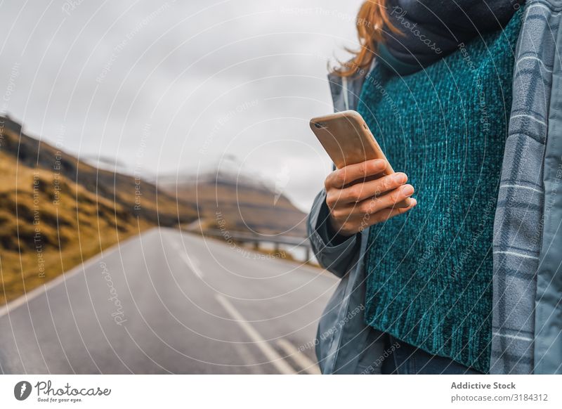 Frau, die das Smartphone hält, steht auf der Straße. PDA Freiheit ruhen Mitteilung ländlich Berge u. Gebirge Ferien & Urlaub & Reisen Freizeit & Hobby Lifestyle