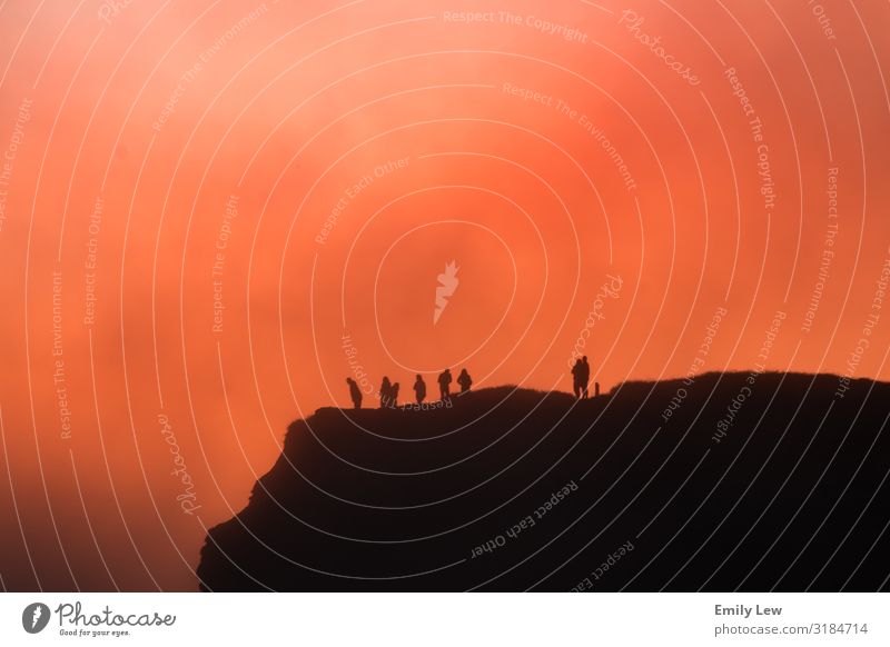 Menschen auf einer Klippe inmitten eines feurigen Sonnenuntergangs Strand Natur Feuer Meer Küste Felsen Landschaft reisen Urlaub Kalifornien Horizont Welt