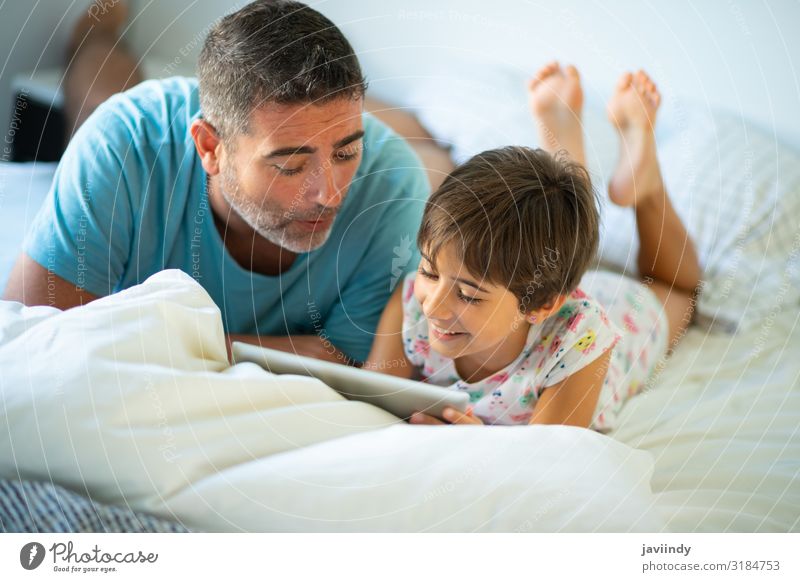 Vater mit achtjähriger Tochter mit digitalem Tablett Lifestyle Glück schön Freizeit & Hobby Spielen Schlafzimmer Kindererziehung Computer Technik & Technologie