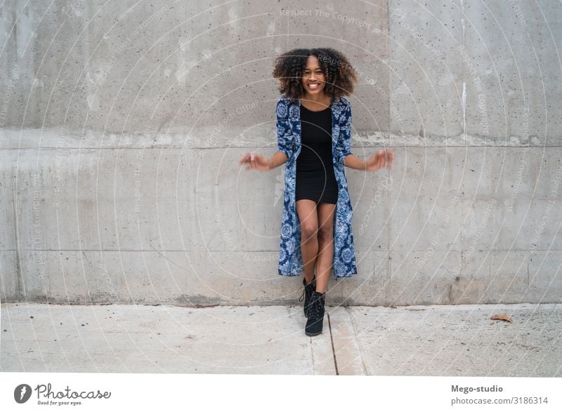 Afroamerikanische Frau gegen graue Wand. Stil Glück schön Gesicht Mensch Erwachsene Mode Bekleidung brünett Afro-Look Lächeln stehen Coolness Freundlichkeit