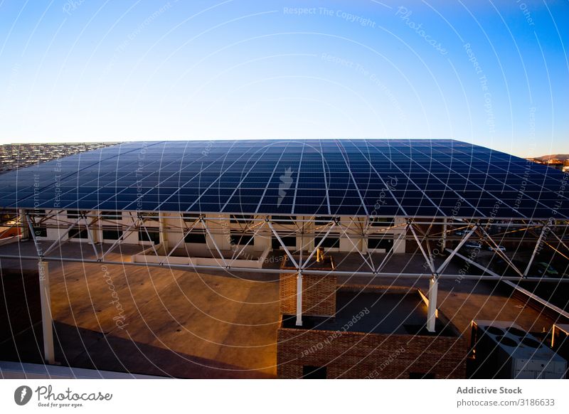 Gebäude mit Dach aus Solarmodulen Sonnenenergie Paneele Großstadt Schönes Wetter Himmel regenerativ Energie modern Außenseite Strukturen & Formen Konstruktion