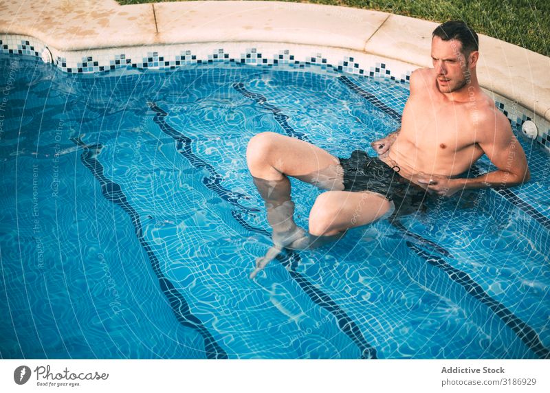Mann, der auf einer Treppe im Pool liegt. Schwimmbad Erholung Schwimmsport Wasser gutaussehend Sommer Resort Ferien & Urlaub & Reisen Freizeit & Hobby