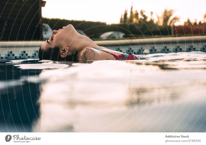 Schöne Frau im Pool Schwimmbad Schwimmsport Jugendliche Wasser Sommer Freizeit & Hobby Blick nach hinten Lifestyle schön Beautyfotografie