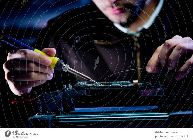 Crop man fixing microchip in der Werkstatt Techniker Löten Mikrochip Technik & Technologie Gerät Werkzeug Arbeit & Erwerbstätigkeit professionell fixieren Mann