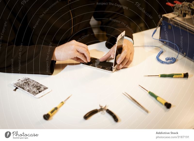 Junger Mann repariert modernes Gerät Techniker reparierend Werkstatt Werkzeuge Tisch Jugendliche Technik & Technologie Aufschlag fixieren Ingenieur Kompetenz