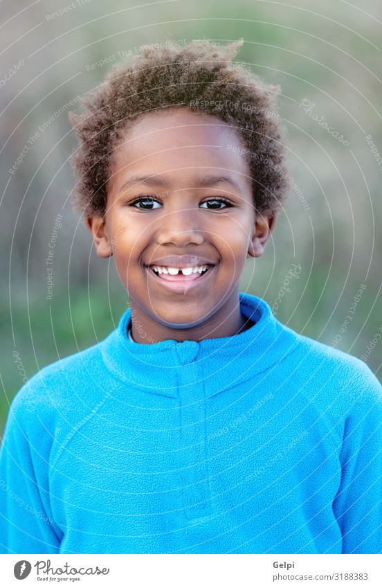 Glückliches afrikanisches Kind mit blauem Trikot Freude Erholung ruhig Freizeit & Hobby Spielen Junge Kindheit Herbst Park Wiese Afro-Look Lächeln träumen