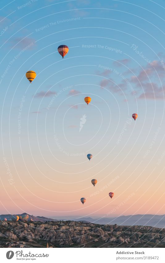 Heißluftballons gegen den untergehenden Himmel Ballone Festspiele Sonnenuntergang Wolken Berge u. Gebirge Düne fliegen Cappadocia Türkei