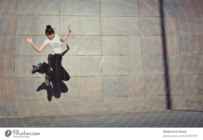 Ein Mädchen, das glücklich auf der Straße springt. Erwachsene Amerikaner Hintergrundbild schön lässig heiter Großstadt Entwurf Frau Freiheit Freundschaft Freude