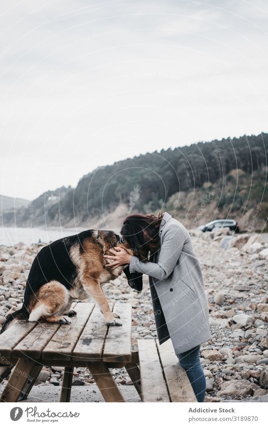 Junge Frau umarmt traurigen Hund am Meer Umarmen Traurigkeit Fürsorge Freundschaft Strand Küste Natur Schäfer Hündchen heimisch Haustier Tier Jugendliche lässig