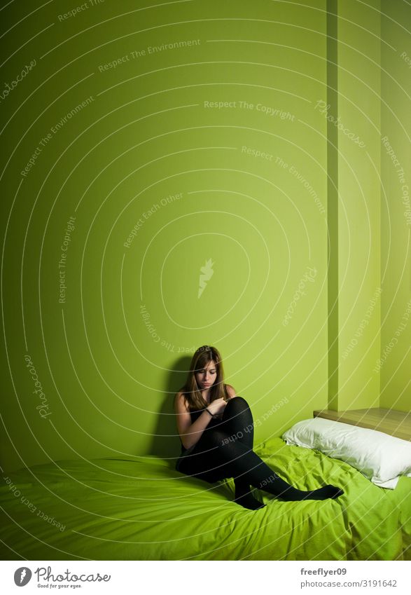 Junge Frau allein auf einem grünen Raum mit hoher Decke Erwachsene Jugendliche Jugendkultur Traurigkeit klein Gefühle Schmerz Einsamkeit Scham Stress