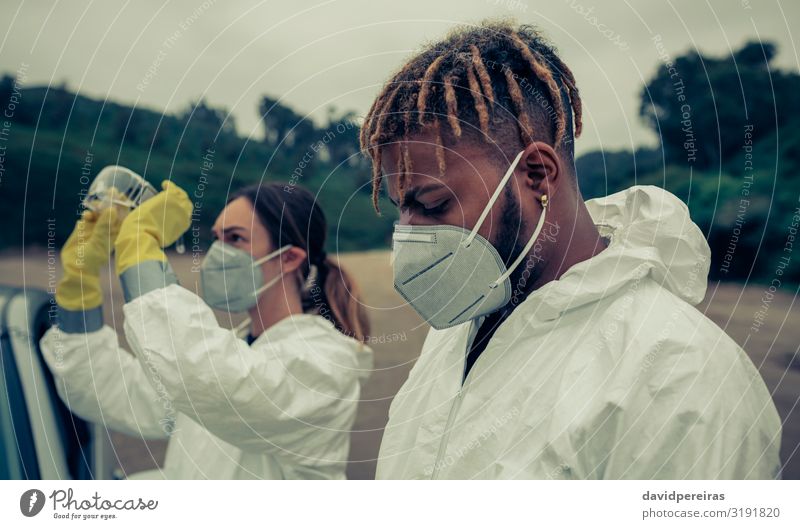 Mann und Frau mit bakteriologischer Schutzausrüstung Mensch Erwachsene Handschuhe schwarz Sicherheit Krise Seuche Virus Schutzanzug Gesichtsschutzmaske Risiko