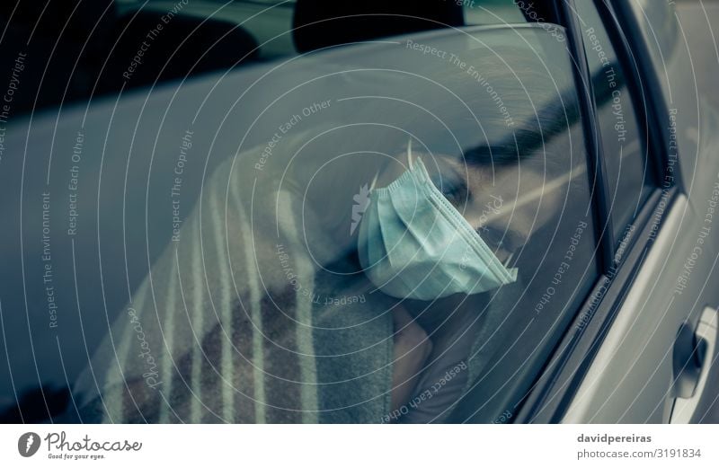 Blick durch die Autoscheibe einer Frau mit Maske Krankheit Medikament Mensch Erwachsene PKW sitzen Schutz Müdigkeit Seuche Virus anmachend Mundschutz
