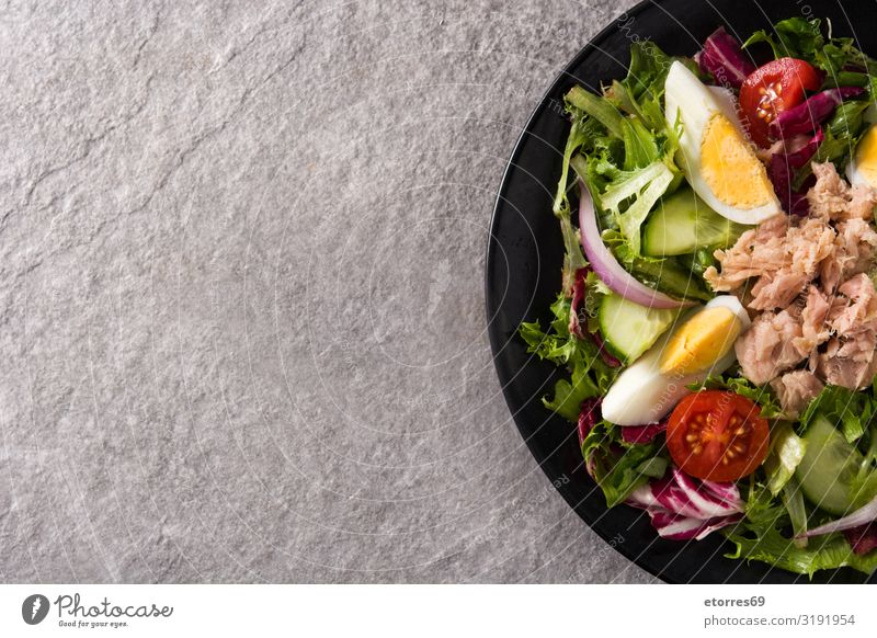 Salat mit Thunfisch, Ei und Gemüse Salatbeilage Tomate Kopfsalat schwarz Teller Zwiebel Gurke Salatgurke Scheibe gemischt Olivenöl Gesunde Ernährung
