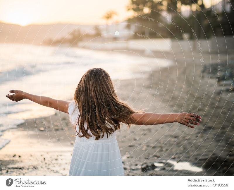Aufgeregtes Mädchen läuft bei Tageslicht am Strand entlang. rennen Aufregung Spaß haben Spielen Kind Küste heiter Seeküste reizvoll Sand Sommer Kindheit Glück