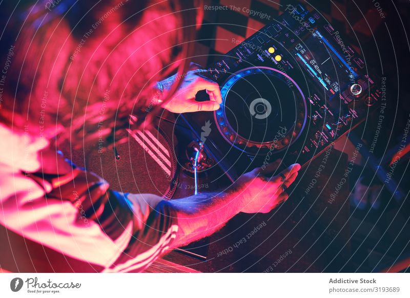 Von oben ein anonymer DJ-Mann, der in einem Club mit Licht spielt. Nachtclub Hand Entertainment Schallplatte Spielen Gerät Plattenteller Party Scheibe