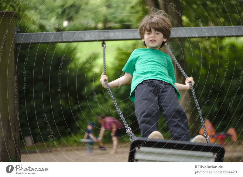 Kind schaukelt auf einem Spielplatz authentisch natürlich Junge Sommer Spaß Glück Freude Schaukel Schaukeln Spielen Kindheit schaukeln ist wie fliegen