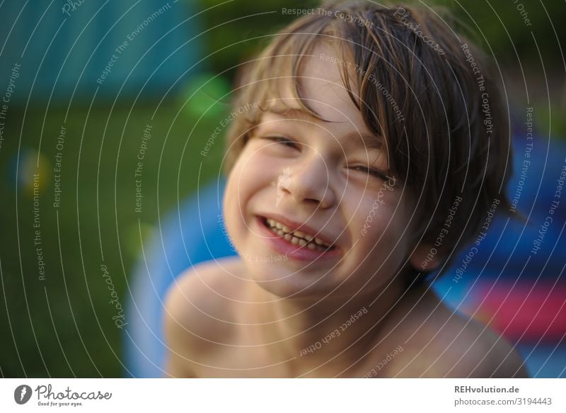 Junge lacht im Garten 7 Jahre glücklich Glück abkühlung warm Lebensfreude Freude Porträt Gesicht Blick in die Kamera Vorderansicht Kindheit Spielen nackt