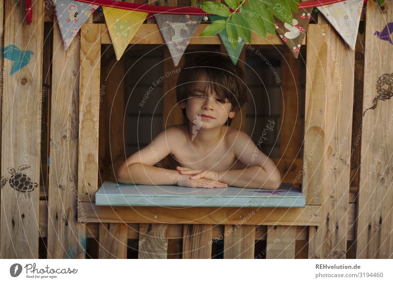 Kind in einer spielhütte im sommer Hütte Spielhaus Haus Fenster Sommer Garten Spielen Farbfoto Holz Kindheit nachdenklich authentisch echt Paletten Natur Junge