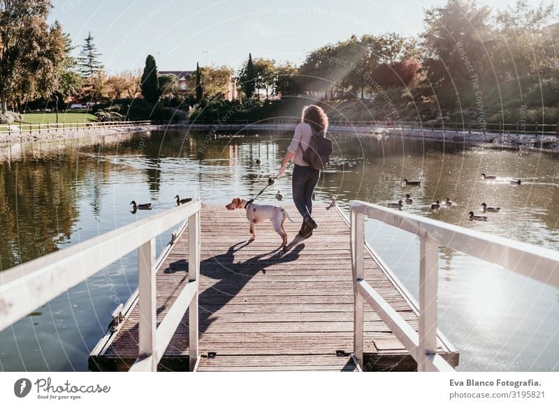 junge Frau und ihr Hund im Freien in einem Park mit einem See. sonniger Tag, Herbstsaison Jugendliche Außenaufnahme Liebe Haustier Besitzer Sonnenstrahlen schön