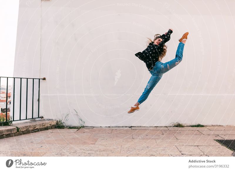 Teenager-Tänzerin, die gegen eine weiße Wand springt. Frau springen Tanzen Spagat Fliege Freiheit Skyline Straße Anmut Unbekümmertheit Inspiration Jugendliche