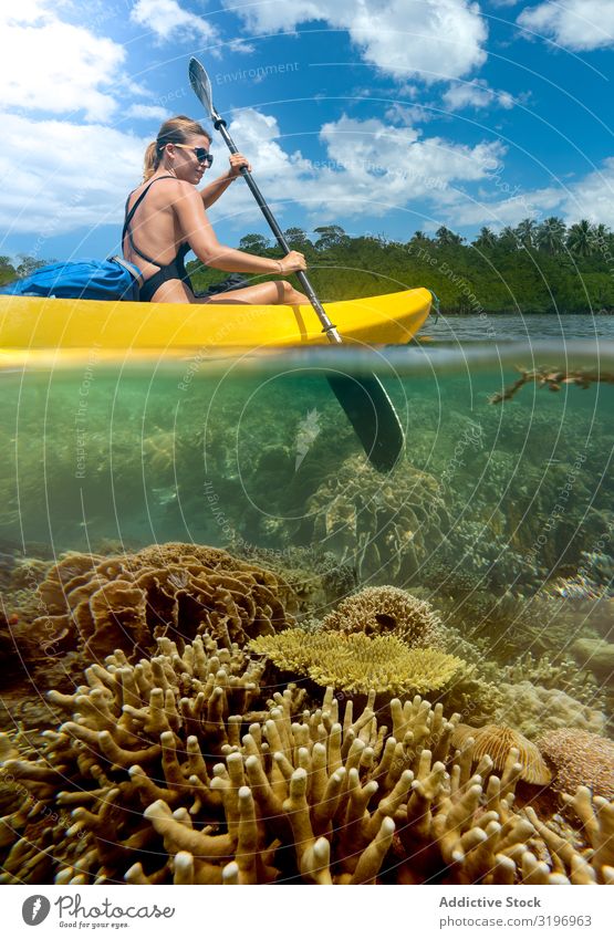 Sportliche Frau auf Kanufahrt in der tropischen Lagune sportlich reisend Tourist Kajak Gesäß malerisch Korallen Jugendliche Unterwasseraufnahme