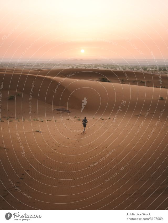 Mann im Sommerhemd, der in der Wüste spazieren geht. Sonnenuntergang Sand Marokko Natur abgelegen Ferien & Urlaub & Reisen Frieden Freiheit modern Barfuß