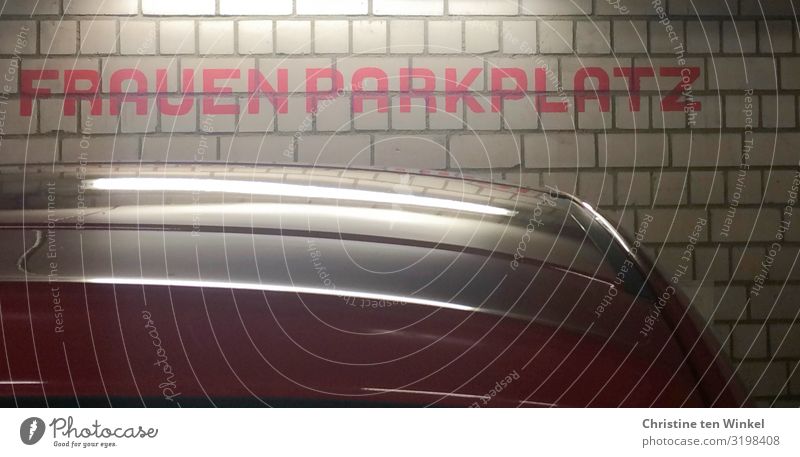 Das Wort "Frauenparkplatz" an einer Wand in einem Parkhaus Mauer PKW Schriftzeichen Schilder & Markierungen authentisch glänzend hell nah Stadt feminin rot weiß