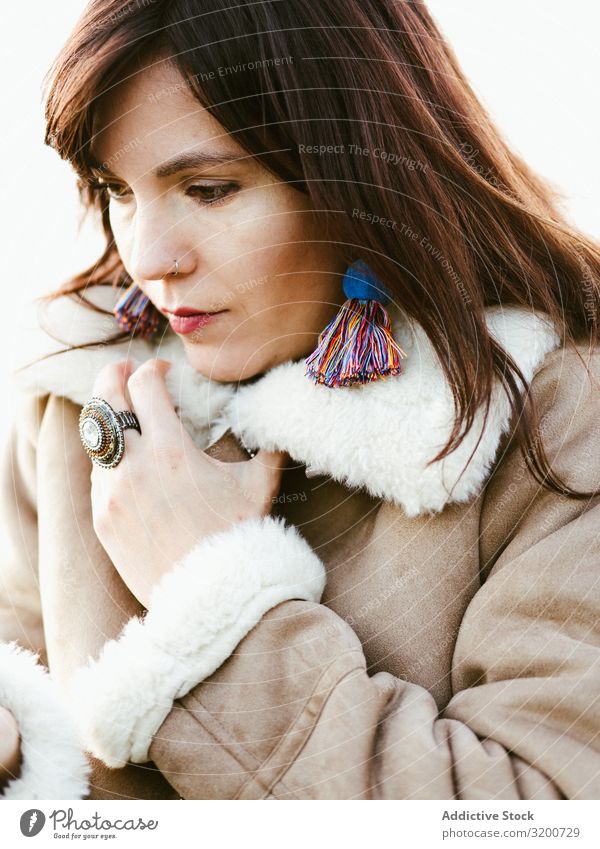 Porträt eines nachdenklichen Modells mit handgefertigten Ohrringen selbstgemacht Fürsorge Frau schön brünett Faser trendy warme Kleidung attraktiv besinnlich